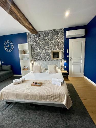 a bedroom with blue walls and a large bed at Hotel LA PLACE in Saint-Amand-Montrond