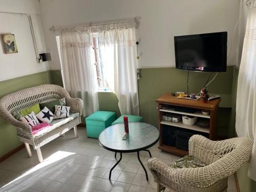 a living room with chairs and a table and a tv at El cóndor in Balneario El Condor