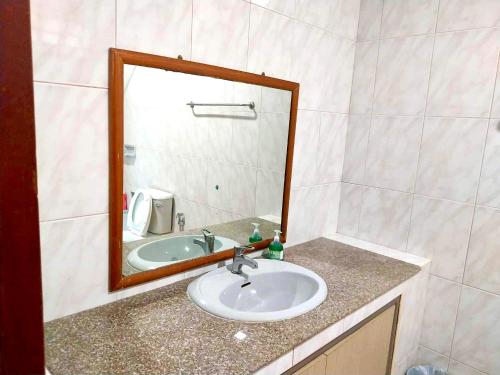 une salle de bain avec un lavabo et un miroir dans l'établissement Mata Villa, à Krabi
