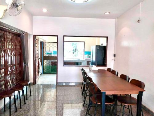 a dining room with a wooden table and chairs at Mata Villa Krabi Town in Krabi