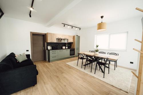 Cozy HillSide في بورشا: غرفة معيشة ومطبخ مع طاولة وكراسي