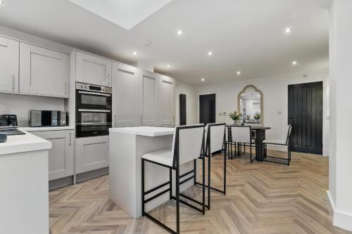 a kitchen with white cabinets and a table with chairs at Newly renovated Atherton home by Train station in Atherton
