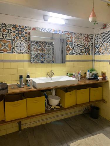 a bathroom with a sink and yellow tiles at Kaz KREOL in Basse-Terre