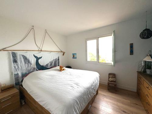 a bedroom with a white bed with a cat sitting on it at vue sur le golfe de Saint Florent in Saint-Florent