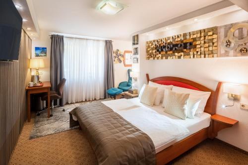 una habitación de hotel con una cama y un escritorio en Aristo Hotel, en Filderstadt