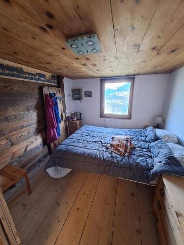 a bedroom with a bed in a log cabin at Appartement Valaisan typique in Guttet-Feschel