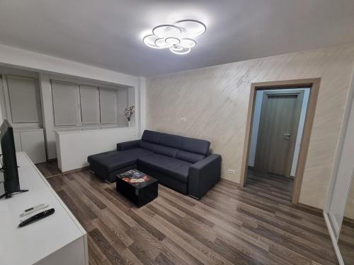 un soggiorno con un divano nero e un tavolo di Ezzely apartment ParkLake a Bucarest