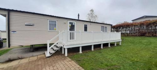 a mobile home with a porch and a white deck at Willerby Escapes in Lytchett Minster