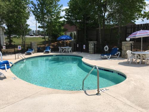 a swimming pool with chairs and a table and umbrella at America's Best Value Inn Conyers in Conyers