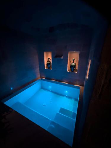 a blue tub in a room with people in mirrors at Victory Suite in Monopoli