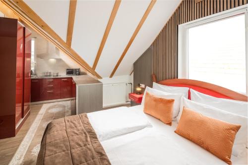 um quarto com uma grande cama branca com travesseiros laranja em Aristo Hotel Stuttgart Airport-Messe em Filderstadt
