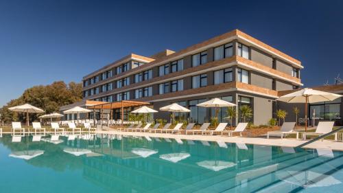 a hotel with a swimming pool in front of a building at Salinas del Almiron Resort Termal in Termas de Almiron