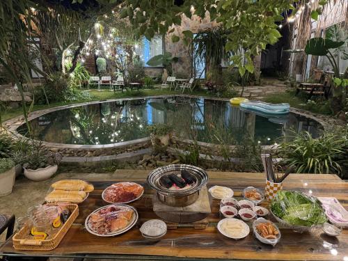 a buffet of food on a table in front of a pool at Mộc Sơn Homestay in Mộc Châu