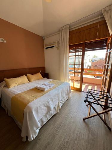 a bedroom with a bed and a large window at Casa Piedra Hotel in Villa Carlos Paz