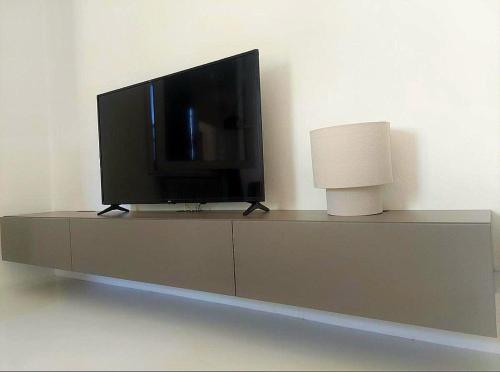 Un televisor de pantalla plana encima de una cómoda. en Villa Maria, en Onno