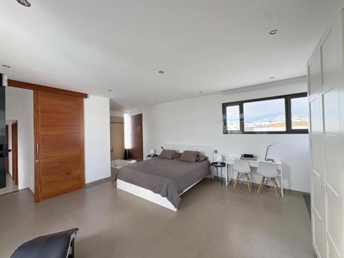 ein Schlafzimmer mit einem Bett und einem Tisch und Stühlen in der Unterkunft Casa Blanca - Villa à Teguise avec piscine privée in Teguise