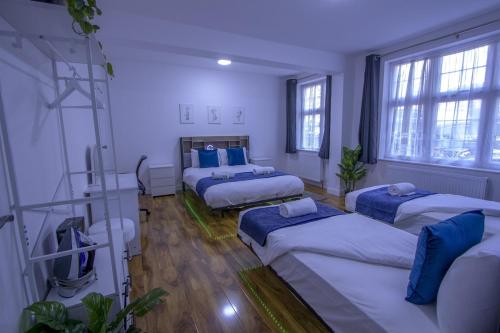 Zimmer mit 4 Betten und Fenstern in der Unterkunft Spacious 3-Bed Detached Home in London-Greenford in Northolt