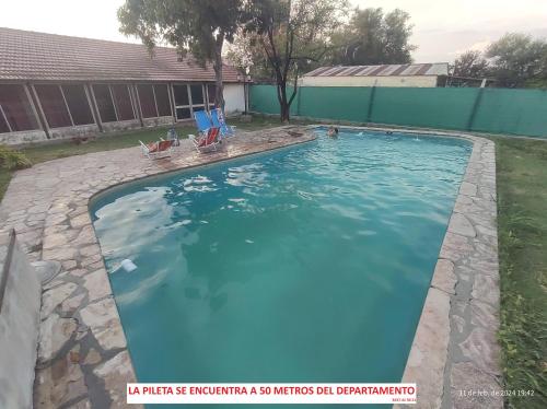 a swimming pool with blue water in a yard at Apart Don Lucio 210 in La Paz