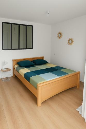 a bedroom with a wooden bed in a room at Grand Studio entier proche de Tours in Esvres