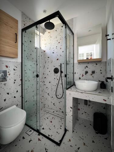 a bathroom with a shower and a toilet and a sink at Green Sea Studio in Rethymno