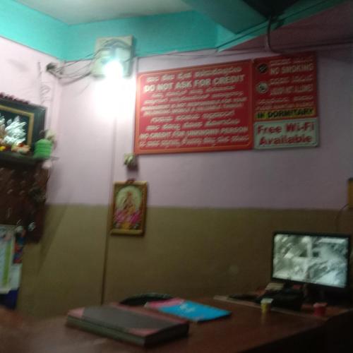 a restaurant with a sign on the wall and a table at V R S Dormitory in Hubli