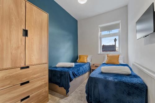 a bedroom with two beds and a large cabinet at Newly renovated Atherton home by Train station in Atherton