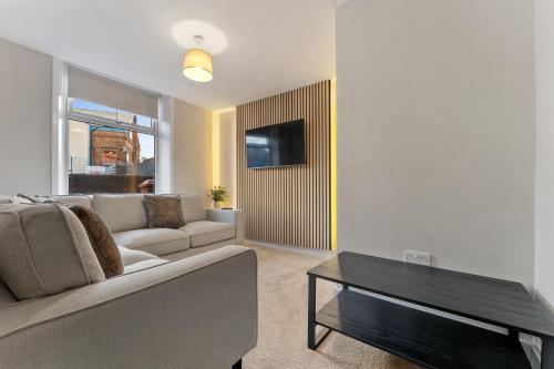 a living room with a couch and a table at Newly renovated Atherton home by Train station in Atherton
