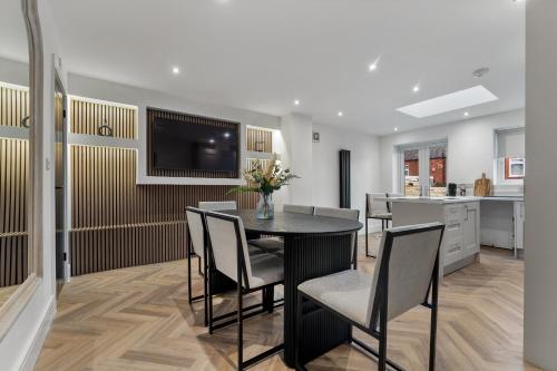 a dining room with a table with chairs and a television at Newly renovated Atherton home by Train station in Atherton