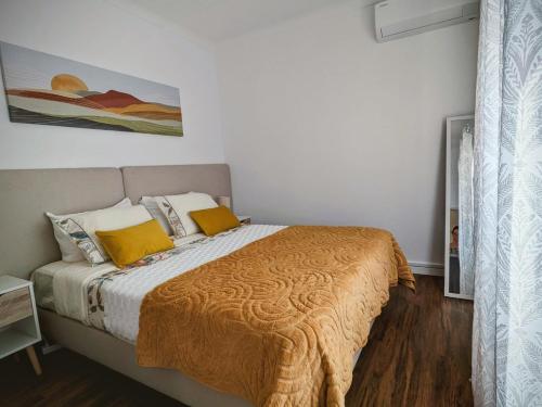 a bedroom with a large bed with yellow pillows at Downtown Guesthouse in Angra do Heroísmo