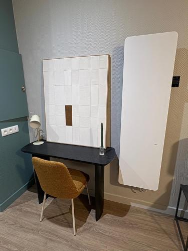 un bureau noir avec un miroir et une chaise dans l'établissement Les Murs By le Clos, à Metz