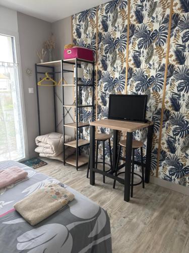 uma sala com uma mesa com um computador em cima em Petit studio attenant à la maison em Saint-Agnant