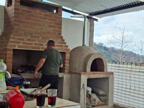 Ein Mann steht vor einem Backsteinofen. in der Unterkunft Establo 2 - Casa Vacacional en Jujuy in San Salvador de Jujuy