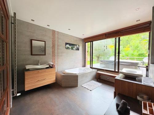 une salle de bain avec une baignoire et un lavabo et une baignoire dans l'établissement Villa Oana - Heated Pool - Jacuzzi, à Paron