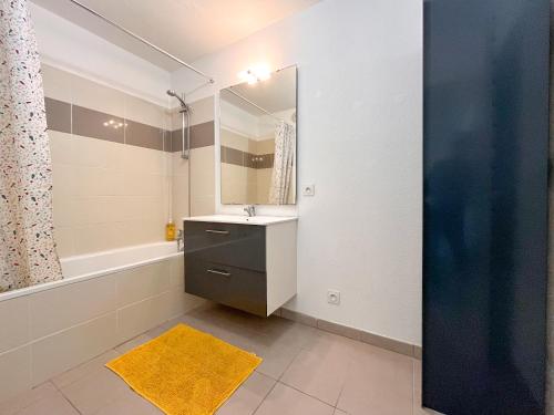 een badkamer met een wastafel, een spiegel en een bad bij Cenon plein ciel in Cenon