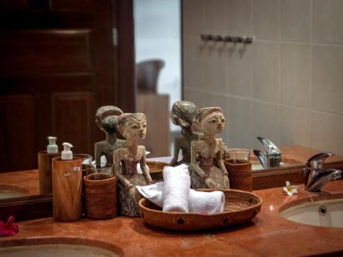 a bathroom counter with a sink with a statue of women at Private Luxury Villa Celagi - with large infinity pool and ocean view in Amed