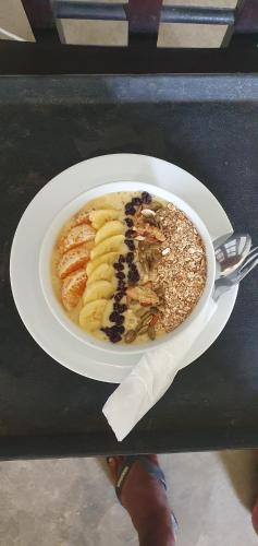 un plato blanco con un tazón de comida en una mesa en Delma Mount View Hotel Kandy, en Aladeniya