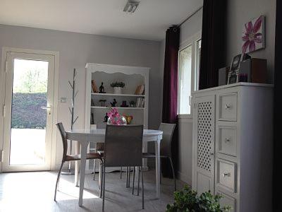 une salle à manger avec une table et des chaises blanches dans l'établissement Gite de la Baie d'Authie, à Groffliers