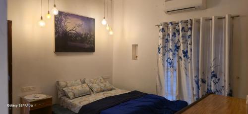 a bedroom with a bed and a painting on the wall at sea zars villa in Cochin