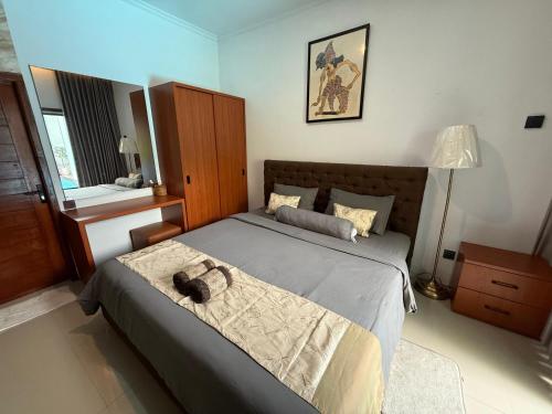 a bedroom with a large bed with a brown headboard at Erindra Villa in Pesanggaran