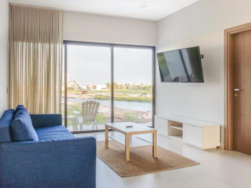ein Wohnzimmer mit einem blauen Sofa und einem Fernseher in der Unterkunft Marina view pool and restaurants nearby in San Rafael