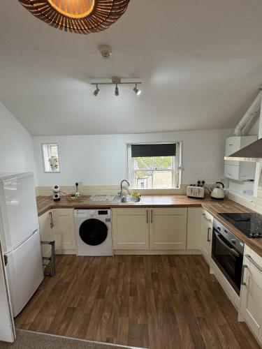 a kitchen with white cabinets and a sink at Kingsmead Square Apartments in Bath