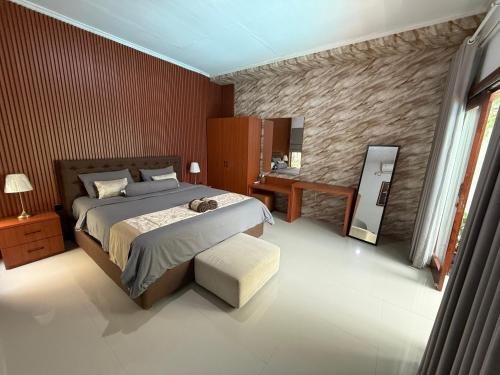 a bedroom with a bed and a chair and a table at Erindra Villa in Pesanggaran