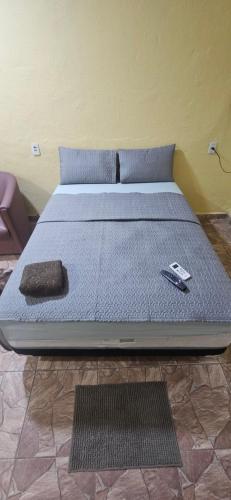 un letto con un materasso blu con un telecomando sopra di Cantinho bom! a Manaus