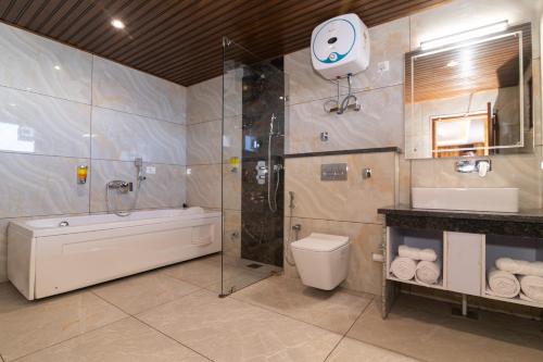 ein Badezimmer mit Dusche, Toilette und Waschbecken in der Unterkunft Elbrus Resort & Spa in Theog