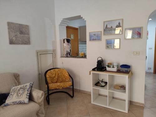 La Casa Di Via Marzulli في أتشيريالي: غرفة معيشة مع كرسي وطاولة