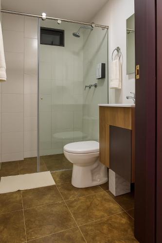 a bathroom with a toilet and a glass shower at Hotel Arisha Cali in Cali