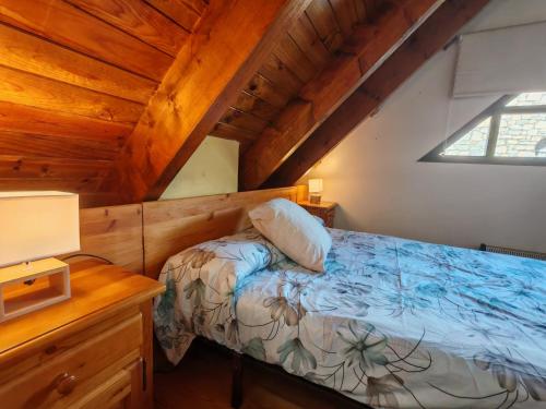 ein Schlafzimmer mit einem Bett und einer Holzdecke in der Unterkunft Dúplex acogedor con chimenea cerca de Aigüestortes - Falcó 6 in Pla de l'Ermita
