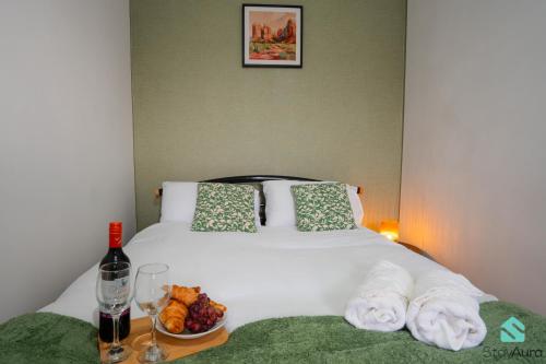 a white bed with a bowl of fruit and a bottle of wine at Beautiful Flat By Stay Aura Contractors Accommodation Newcastle With Free Parking in Gateshead