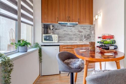 une cuisine avec une table en bois et une petite table et une cuisine dans l'établissement Forestside Stay at Stream Resort, à Pamporovo