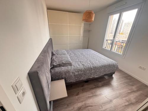 Un dormitorio con una cama y una ventana en Maison chaleureuse, en Puteaux